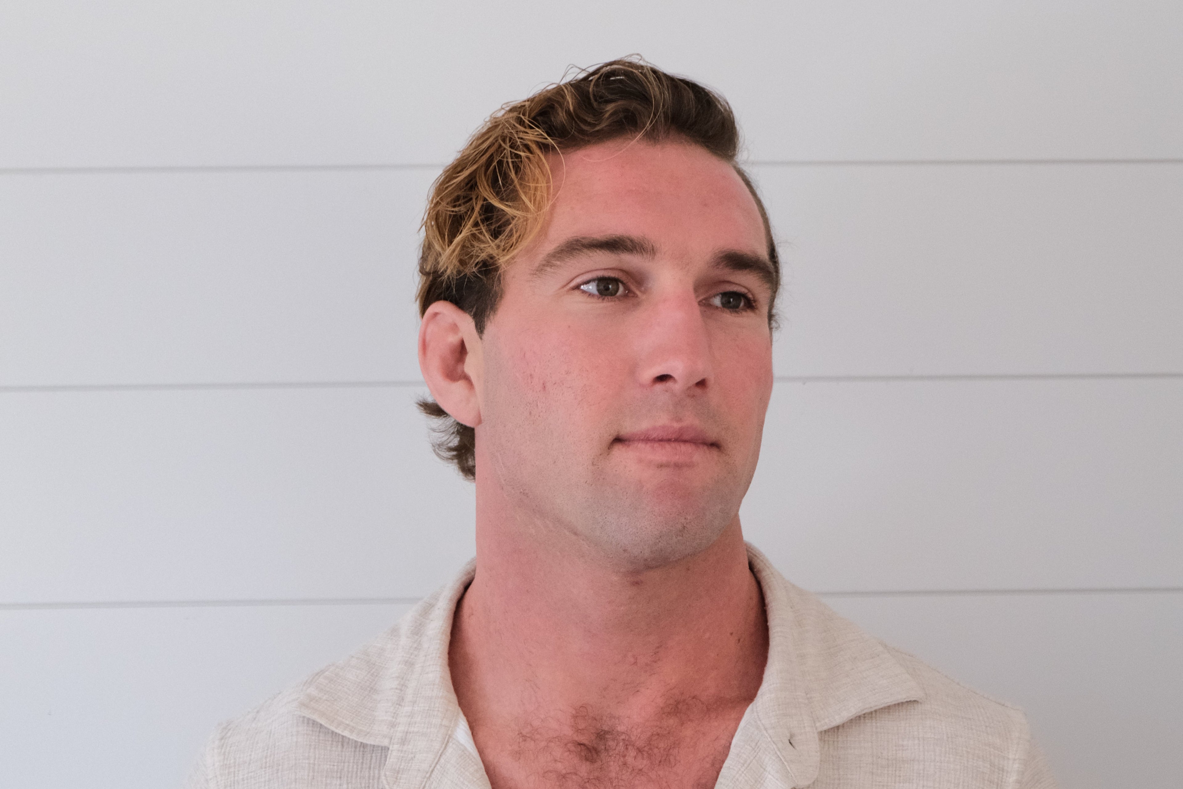 Man wearing a beige shirt against a white background